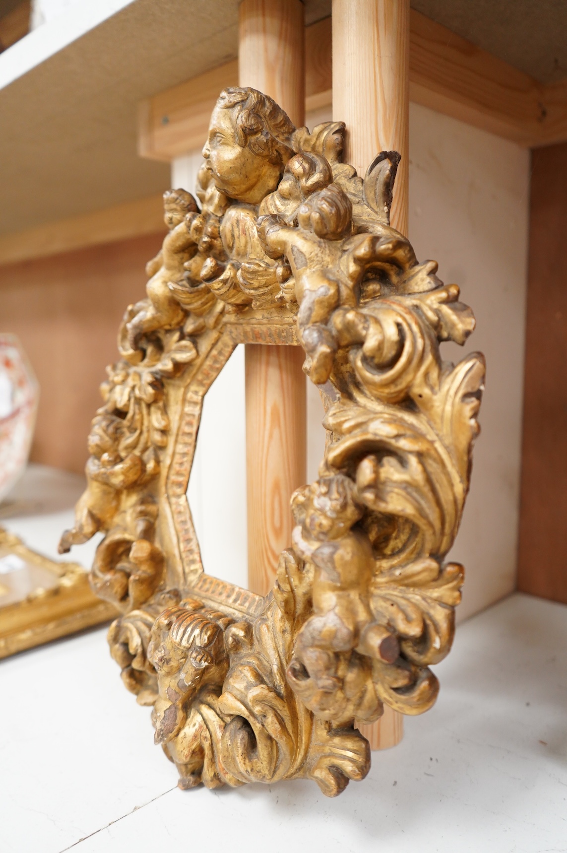 A late 17th/early 18th century Italian carved giltwood cherub frame with octagonal aperture, 37cm high